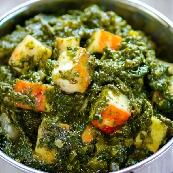 Close-up of Everest Indian Kitchen's Palak Paneer, a vibrant green spinach curry with cubes of paneer cheese.