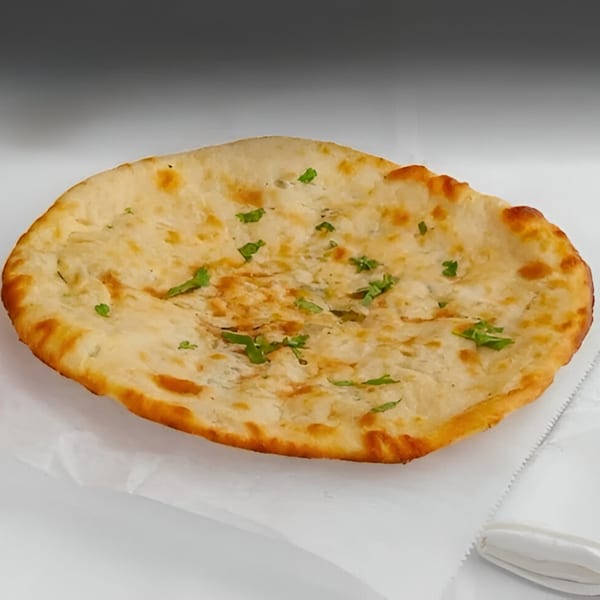 Everest Indian Kitchen's naan bread, golden brown with green herbs, on white paper.